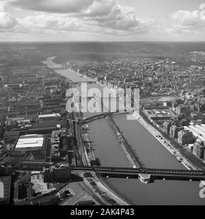 1950s, historical, aerial view from the Eiffel Tower over the river Seine and the city of Paris, France, showing the bridges of the day, including the little 'Statue of Liberty' positioned on the ile aux Cygnes (Isle of the Swans) in the middle of the river. Stock Photo