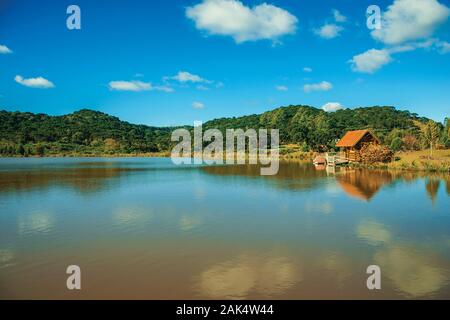 Small rustic shack reflected on the lakeside of crystal clear water near Cambara do Sul. A town with natural tourist sights in southern Brazil. Stock Photo