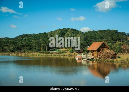 Small rustic shack reflected on the lakeside of crystal clear water near Cambara do Sul. A town with natural tourist sights in southern Brazil. Stock Photo