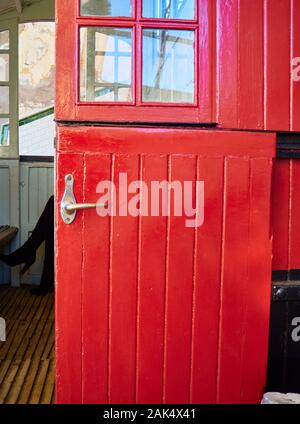 Antique red wooden door with a metallic door handle. Stock Photo