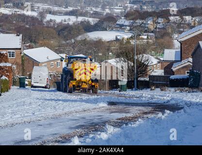 A tractor towing a grit spreader on Langley Lane in Baildon, Yorkshire. Stock Photo