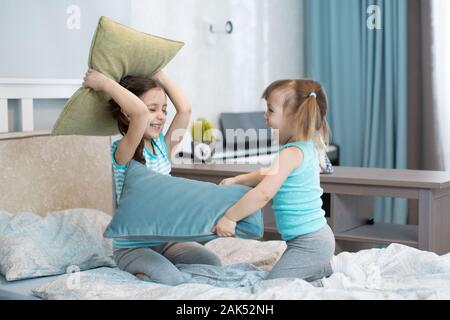 Little kids girls play using pillows in bedroom Stock Photo