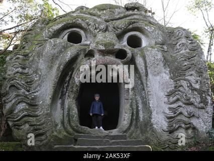 (200107) -- BOMARZO, Jan. 7, 2020 (Xinhua) -- A girl plays at the Park of Monsters in Bomarzo, Italy, Jan. 3, 2020. Bomarzo, a village in Lazio at the foot of Mount Cimino, possesses a unique work, the Villa of Marvels, also called the Sacred Wood or Park of Monsters. lt was designed by Duke of Bomarzo, Vicino Orsini and architect Pirro Ligorio in 1552.This ltalian style garden follows geometric and perspective rationality with embellishments such as wide terraces, fountains with water games and mannerist sculptures. (Xinhua/Cheng Tingting) Stock Photo