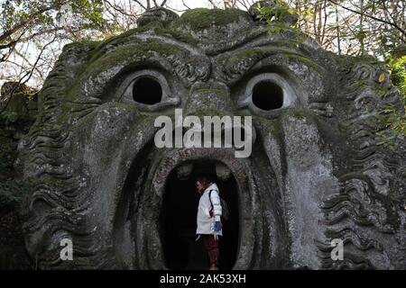 (200107) -- BOMARZO, Jan. 7, 2020 (Xinhua) -- A woman visits the Park of Monsters in Bomarzo, Italy, Jan. 3, 2020. Bomarzo, a village in Lazio at the foot of Mount Cimino, possesses a unique work, the Villa of Marvels, also called the Sacred Wood or Park of Monsters. lt was designed by Duke of Bomarzo, Vicino Orsini and architect Pirro Ligorio in 1552.This ltalian style garden follows geometric and perspective rationality with embellishments such as wide terraces, fountains with water games and mannerist sculptures. (Xinhua/Cheng Tingting) Stock Photo