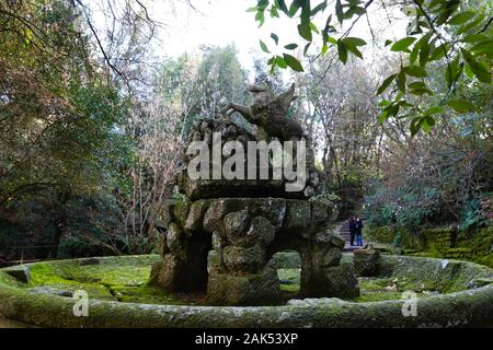 (200107) -- BOMARZO, Jan. 7, 2020 (Xinhua) -- People visit the Park of Monsters in Bomarzo, Italy, Jan. 3, 2020. Bomarzo, a village in Lazio at the foot of Mount Cimino, possesses a unique work, the Villa of Marvels, also called the Sacred Wood or Park of Monsters. lt was designed by Duke of Bomarzo, Vicino Orsini and architect Pirro Ligorio in 1552.This ltalian style garden follows geometric and perspective rationality with embellishments such as wide terraces, fountains with water games and mannerist sculptures. (Xinhua/Cheng Tingting) Stock Photo