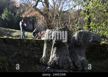 (200107) -- BOMARZO, Jan. 7, 2020 (Xinhua) -- People visit the Park of Monsters in Bomarzo, Italy, Jan. 3, 2020. Bomarzo, a village in Lazio at the foot of Mount Cimino, possesses a unique work, the Villa of Marvels, also called the Sacred Wood or Park of Monsters. lt was designed by Duke of Bomarzo, Vicino Orsini and architect Pirro Ligorio in 1552.This ltalian style garden follows geometric and perspective rationality with embellishments such as wide terraces, fountains with water games and mannerist sculptures. (Xinhua/Cheng Tingting) Stock Photo