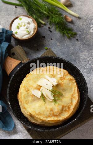 Stack Potato pancakes, not sweet, served with garlic cream sauce on a gray stone background. Stock Photo