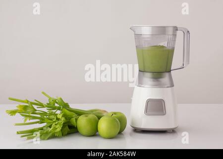celery and apples with blender on white background, healthy eating concept Stock Photo