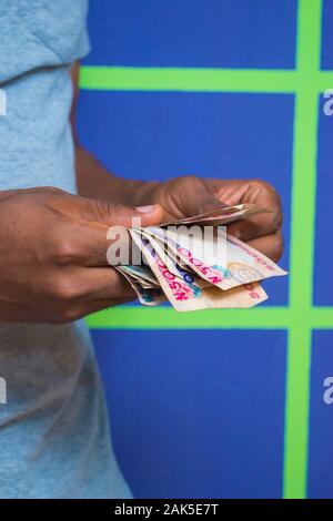 a young African Nigerian man counting his money Stock Photo