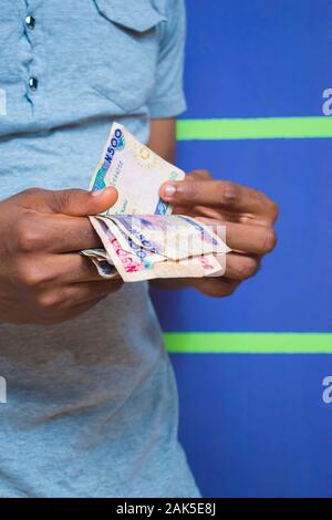 a young African Nigerian man counting his money Stock Photo