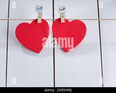 Two red hearts set on string over white background. Valentine's day concept. Space for text Stock Photo