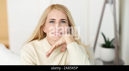 Portrait of middle-aged woman smiling to camera, holding hand near face, panorama Stock Photo