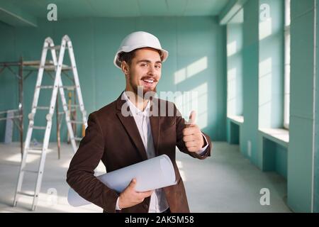 Foreman bearded man in a white helmet in a room at a construction site. Stock Photo