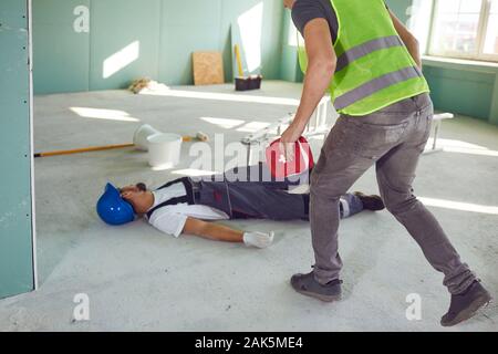 Construction worker accident with a construction worker. First aid for injury at work. Stock Photo