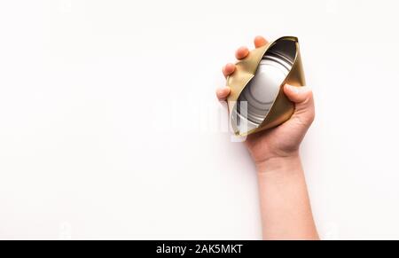 The concept of separate trash. Woman hand holds a crumpled tin can on a white isolated background, copy space Stock Photo