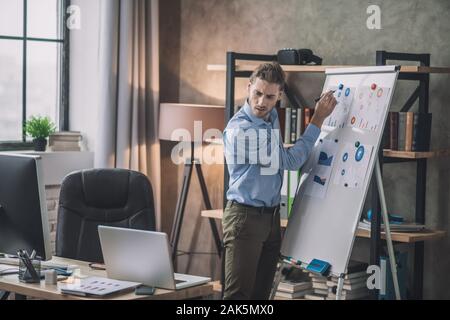 Drafting schemes. Young web designer in eyeglasses making drafts Stock Photo