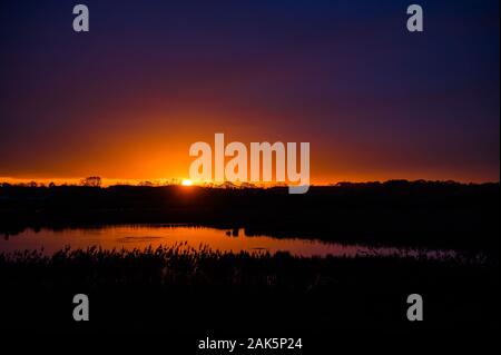 Sunset over the wetlands and woodlands, Lunt Meadows RSPB Nature Reserve, Merseyside Stock Photo