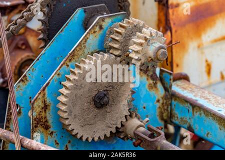 Gear dirty rusty and greasy element details of old farm agricultural machine. Colorful close-up picture, moody late autumn day, abandoned outdoors, Bulgaria Stock Photo