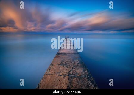 Long exposure seascape fine art photograph of pier on a sunrise in Paphos, Cyprus Stock Photo