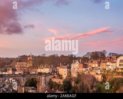 Railway Viaduct with St Johns Church and crag top houses at dusk from the Castle Grounds in Knaresborough North Yorkshire England Stock Photo