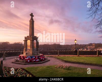 Pink sky at dusk over the War Memorial in the Catle Grounds at Knaresborough North Yorkshire England