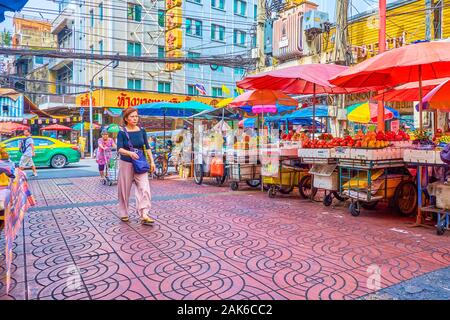 BANGKOK, THAILAND - APRIL 15, 2019: The small grocery carts are the typical Chinatown market's moving stalls, located in narrow alleys aside of Yaowar Stock Photo