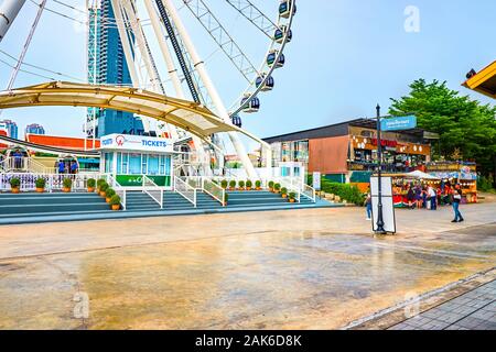 BANGKOK, THAILAND - APRIL 15, 2019: The small square with the entrance to the Ferris wheels in Asiatique, the riverfront mall, on April 15 in Bangkok Stock Photo