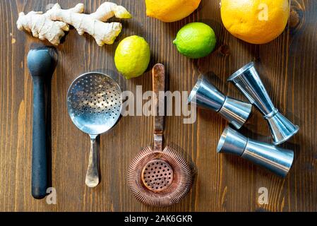 Set of a bartender accessories with fruits and ginger roots on a dark wooden table view from the top Stock Photo