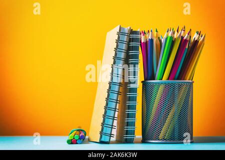 Various notebooks and pencils on a colored background with copy space Stock Photo