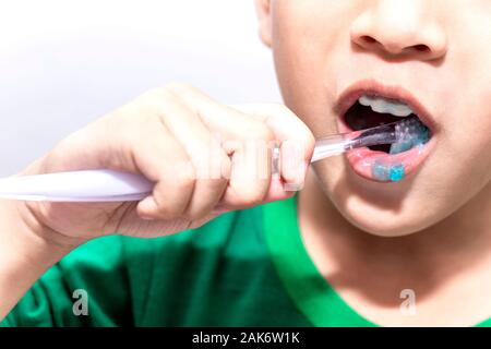 Little asian boy with toothbrush cleaning teeth in the bathroom. Close up kid brushing his teeth. health care and dental hygiene concept. Stock Photo