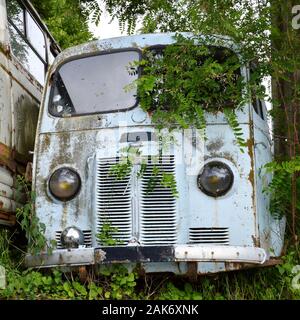 A old destroyed and obsolete truck abandonned in middle of countryside, in the nature Stock Photo