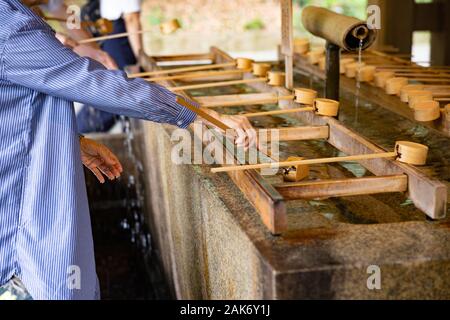 Woman with traditional ladle in Buddhist temple Stock Photo