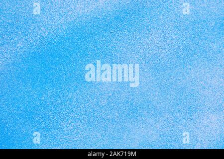 Metallic texture with paint sprayed on it with white and blue. Close up. Stock Photo