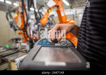 Man programming robot in automotive industrial, professional programmer, industry concept Stock Photo