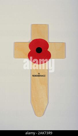 A single red poppy on a small wooden cross commemorating remembrance day in the UK. Stock Photo