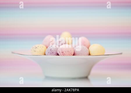 Sugar shell covered chocolate eggs in small dish Stock Photo
