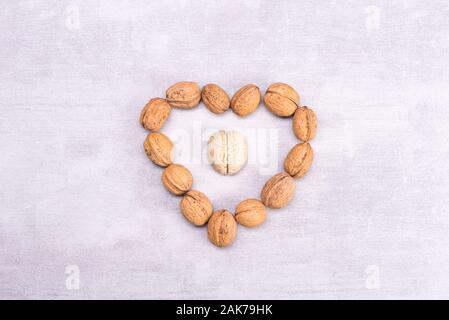 Walnuts love healthy brain foods. The shape of the human brain is surrounded by walnut kernels in the shape of a heart Stock Photo