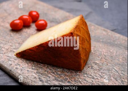 Cheese collection, piece of Spanish manchego cheese made from cow milk with red paprika close up Stock Photo