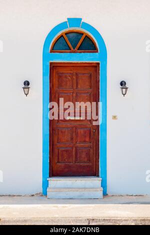 Door background. Building exterior of wooden door between two outdoor lights. Part of exterior. Old door andon grey wall. Part of the building. Wall with door on white wall background Stock Photo