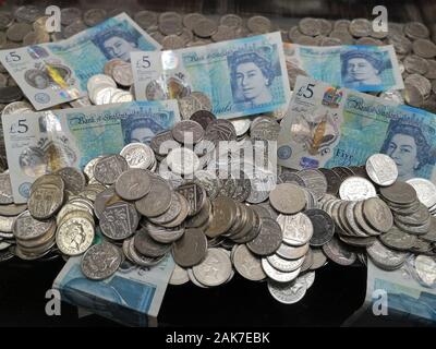 Money is seen in a 'coin pusher' arcade game in Swanage, Dorset, November 2019. Stock Photo