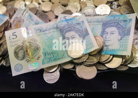 Money is seen in a 'coin pusher' arcade game in Swanage, Dorset, November 2019. Stock Photo