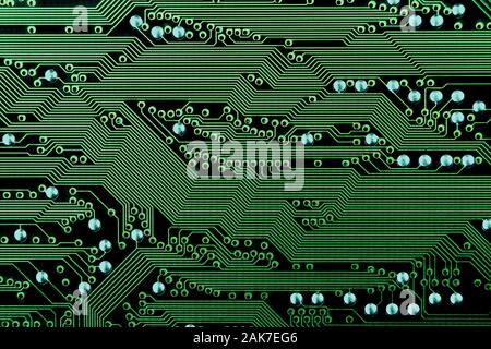 Green abstract electronic circuit board background texture with conductor tracks going horizontal Stock Photo