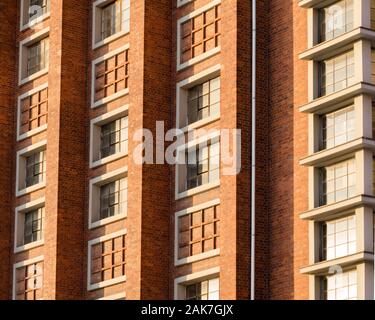 A silver gutter is attached to the red brick facade Stock Photo