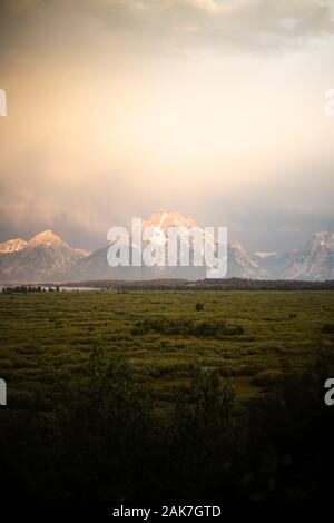 Sunrise View of the Teton Mountain Range with ominous cloud cover and sunlight from the Jackson Lake Lodge in Grand Teton National Park, Wyoming, USA Stock Photo