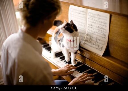 woman-playing-piano-with-cat-