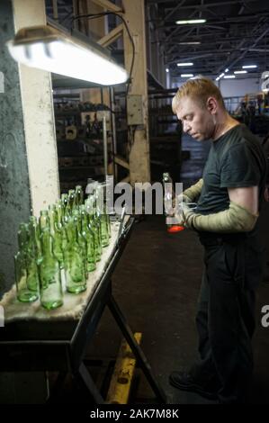 Worker controls quality of bottle, Tyumen. Russia Stock Photo