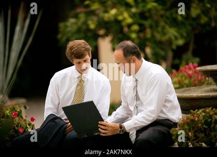 Two business executives working on a laptop. Stock Photo