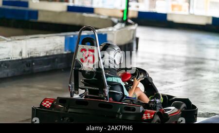Mackay, Queensland, Australia - January 2020: A young boy drives a go-kart in a fun race around an indoor circuit Stock Photo