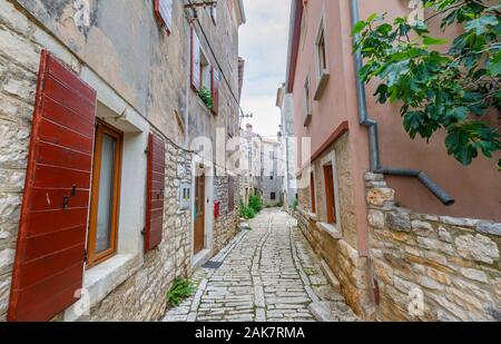A narrow paved alleyway between old buildings in the historic old town in Bale, a small hill town on Mont Perin in Istria County, Croatia Stock Photo