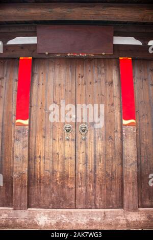 The empty wooden Plaque and Spring Festival couplets without text on the traditional chinese wooden door with brass handle during the Chinese New Year Stock Photo